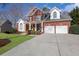 A red brick two-story home with a large front yard at 3995 Vista Point Ln, Suwanee, GA 30024