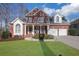 Charming two-story brick home featuring a well-manicured lawn, two-car garage, and welcoming front porch at 3995 Vista Point Ln, Suwanee, GA 30024