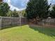 Spacious backyard with a grassy lawn, surrounded by a wooden fence, and a soccer net at 735 Briarhurst Ct, Lawrenceville, GA 30046