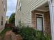 The side exterior features stone accents, green vinyl siding, a small yard, and a brick pathway at 735 Briarhurst Ct, Lawrenceville, GA 30046