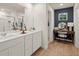 Bright bathroom featuring double sinks, a vanity with stool, and modern fixtures at 8523 Poston Place Lot 132, Douglasville, GA 30134