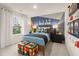 A themed bedroom featuring a game themed wall, and natural light from the window at 8523 Poston Place Lot 132, Douglasville, GA 30134