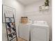 Functional laundry area with modern appliances, a shelf, and decorative ladder at 8523 Poston Place Lot 132, Douglasville, GA 30134