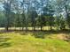Lush backyard view featuring a sprawling green lawn and mature trees, providing privacy and a natural setting at 3624 Peeksville Rd, Locust Grove, GA 30248