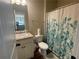 Bright bathroom featuring a single sink vanity and a shower with a botanical curtain at 3624 Peeksville Rd, Locust Grove, GA 30248