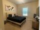 Bedroom featuring modern decor, a queen-sized bed with black linens, and a large window at 3624 Peeksville Rd, Locust Grove, GA 30248