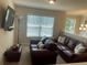 Upstairs bonus room featuring leather sofas, a large window, and a TV at 3624 Peeksville Rd, Locust Grove, GA 30248