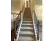 Carpeted staircase leading to the second floor, featuring dark wood banisters and iron balusters at 3624 Peeksville Rd, Locust Grove, GA 30248