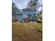 A two-story home displays its blue siding, wooden deck, and enclosed porch in the backyard setting at 9936 Point Vw, Jonesboro, GA 30238