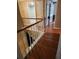 Upstairs hallway showing wood floors, white railing with a wood bannister, and two open doors at 9936 Point Vw, Jonesboro, GA 30238