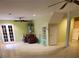 Spacious living room area featuring white tile flooring, a ceiling fan, and double doors at 9936 Point Vw, Jonesboro, GA 30238