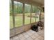 Sunroom features tiled floors, a ceiling fan and expansive windows with views of the green backyard at 9936 Point Vw, Jonesboro, GA 30238