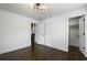 Minimal bedroom with dark wood floors, modern lighting, and access to a closet and other rooms at 1272 Hardee Ne St, Atlanta, GA 30307