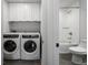 Modern laundry room featuring new washer and dryer, storage, and adjacent full bathroom at 1272 Hardee Ne St, Atlanta, GA 30307