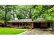 A single-story brick home features a front porch, a carport, and a well-maintained lawn at 6470 Sherwood Trl, Austell, GA 30168