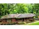 Ranch-style brick home with a covered porch and a carport surrounded by lush greenery at 6470 Sherwood Trl, Austell, GA 30168