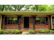 Inviting front porch featuring unique iron supports and lush landscaping at 6470 Sherwood Trl, Austell, GA 30168