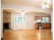 Open concept living room with stone fireplace, hardwood floors and a doorway to kitchen at 6470 Sherwood Trl, Austell, GA 30168