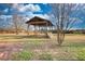 A wooden gazebo with wooden benches in a field with trees and a clear sky at 26 Loyd Cemetery Rd, Newborn, GA 30056