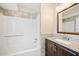 Bright bathroom featuring a granite vanity, framed mirror, updated fixtures, and a tub and shower with tile surround at 407 Paper Mill Lndg, Roswell, GA 30076