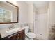 Bright bathroom featuring a granite vanity, framed mirror, updated fixtures, and a shower with tile surround at 407 Paper Mill Lndg, Roswell, GA 30076