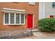 Townhome exterior showcasing a red door, window box, and manicured bushes for curb appeal at 407 Paper Mill Lndg, Roswell, GA 30076