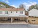 Townhome with covered carport and neutral siding against a backdrop of trees and sky at 407 Paper Mill Lndg, Roswell, GA 30076