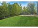 View of the expansive, green backyard with a stone patio and ample privacy provided by mature trees at 56 Ruth Way, Douglasville, GA 30134