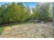 Backyard stone patio with outdoor kitchen and manicured lawn at 56 Ruth Way, Douglasville, GA 30134