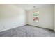 This bedroom features neutral carpet and paint, a vaulted ceiling and a single window at 56 Ruth Way, Douglasville, GA 30134