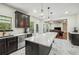 Well-lit kitchen featuring black cabinetry, stainless steel appliances, and a large island with seating at 56 Ruth Way, Douglasville, GA 30134