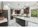 Modern kitchen with black cabinets, stainless steel appliances, an island with bar seating, and elegant lighting at 56 Ruth Way, Douglasville, GA 30134