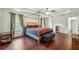 Spacious main bedroom featuring a four-poster bed, tray ceilings, and wood flooring at 56 Ruth Way, Douglasville, GA 30134