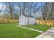 A white shed with backyard landscaping, lush green lawn, and wood privacy fence create a serene outdoor space at 897 Marie Lane Sw Ln, Conyers, GA 30094