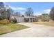 The exterior of the home shows the driveway leading to the two-car garage and manicured landscaping at 897 Marie Lane Sw Ln, Conyers, GA 30094