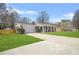 Single-story brick home featuring an attached garage, a long driveway, and a well-maintained green lawn at 897 Marie Lane Sw Ln, Conyers, GA 30094