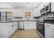 Modern kitchen with white cabinets, a granite countertop, stainless steel appliances, and hardwood floors at 897 Marie Lane Sw Ln, Conyers, GA 30094