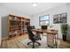 Home office with built in shelving, wood floors, plush rug, modern desk and large picture window at 897 Marie Lane Sw Ln, Conyers, GA 30094