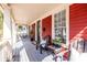 Long front porch with gray painted wood, chairs and red painted siding at 944 Cherokee Se Ave, Atlanta, GA 30315