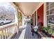 Long front porch with gray painted wood and supporting white columns at 944 Cherokee Se Ave, Atlanta, GA 30315