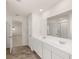 Bathroom with a double sink vanity, large mirror, and view into a bedroom at 1038 Blue Juniper Cir, Loganville, GA 30052