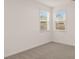 Carpeted bedroom with two windows offering natural light and neighborhood views at 1038 Blue Juniper Cir, Loganville, GA 30052