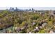 Aerial view showing the neighborhood homes in a verdant setting, with a city skyline in the background at 15 Northwood Ne Ave, Atlanta, GA 30309