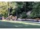 Community playground featuring slides and swings surrounded by lush greenery and stairs leading up a hill at 15 Northwood Ne Ave, Atlanta, GA 30309