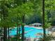 Community pool surrounded by lush greenery, umbrellas, and lounge chairs for residents to enjoy at 15 Northwood Ne Ave, Atlanta, GA 30309