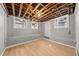 Unfinished basement with wooden floor, concrete walls, exposed ceiling, and natural light from three windows at 1707 Terry Mill Road Se Rd, Atlanta, GA 30316