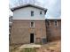 Back exterior view of brick home with siding, windows, door and concrete pad, plus partial view of AC unit at 2724 Hickory Smoke Ct, Snellville, GA 30078