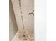 Tiled shower featuring decorative mosaic insets and pebble flooring at 2724 Hickory Smoke Ct, Snellville, GA 30078