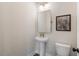 Stylish powder room featuring a pedestal sink, modern mirror, decorative lighting, and elegant artwork at 508 Boardwalk Way, Alpharetta, GA 30022