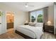 Bedroom with ensuite bathroom entrance featuring large windows, modern ceiling fan and stylish decor at 508 Boardwalk Way, Alpharetta, GA 30022